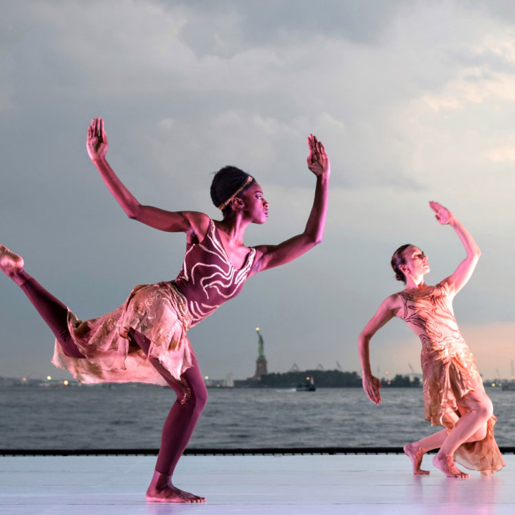 Two contemporary dancers performing near Statue of Liberty